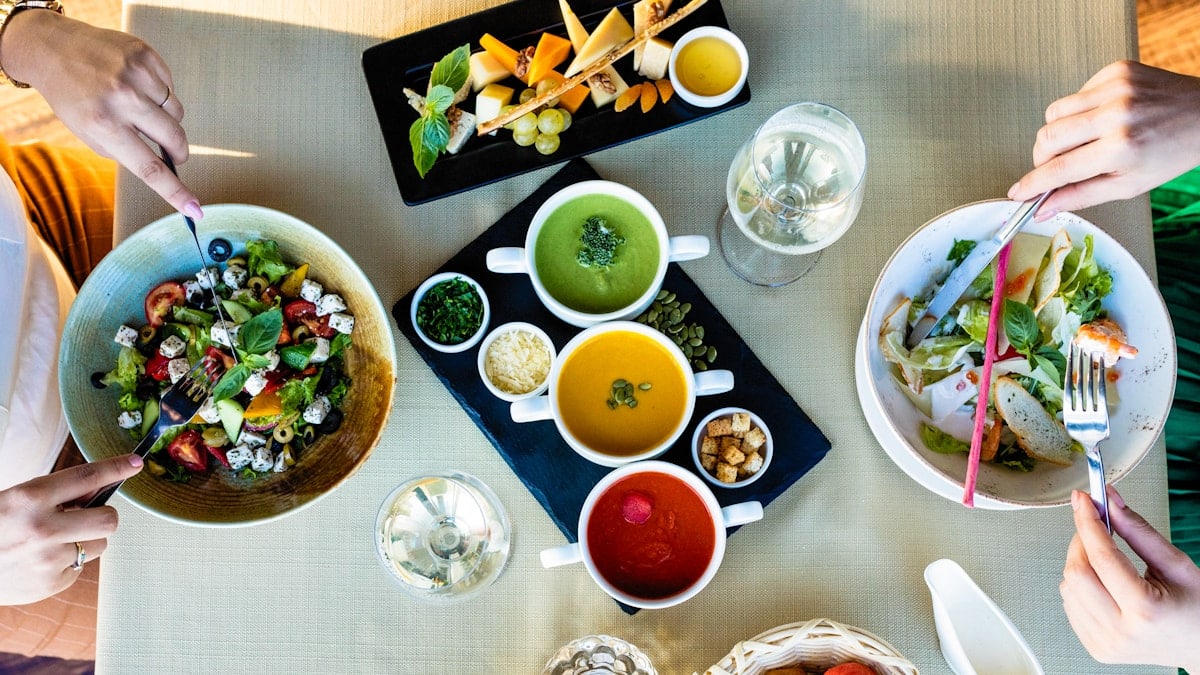 Eating cheese, chicken salad with different soups on the table